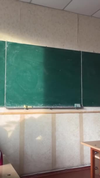 パブリックスクールの緑のボードで窓から入ってくる空の教室 机が見える ボード上の太陽の光は教室を教える通常の日です — ストック動画