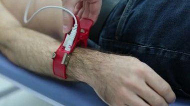 Bir kardiyolog hastaya kardiyogram yapar. Profesyonel doktorun kadın elleri modern klinikteki hasta adamı daha detaylı incelemek için kardiyogramı tutar. Tıptaki son teknolojiler. 
