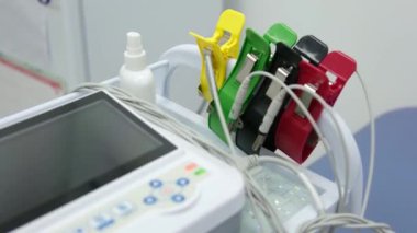 Bir kardiyolog hastaya kardiyogram yapar. Profesyonel doktorun kadın elleri modern klinikteki hasta adamı daha detaylı incelemek için kardiyogramı tutar. Tıptaki son teknolojiler. 