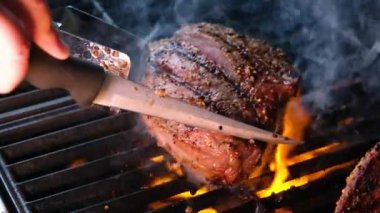 Ateşli, sulu, pişmiş et dilimlerinin yakından görüntüsü. Orijinal yemek tarifi. Profesyonel aşçılık, yemek tarifi, yemek pişirme. Ateşin üstünde biftek pişirirken çekilmiş kaliteli bir video.