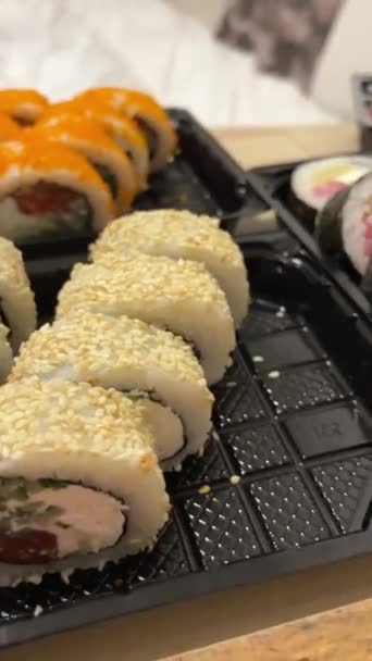 寿司の配達セット プラスチック容器の寿司 実生活の近いカリフォルニアのロール あなたの家への飛行魚のキャビアの食糧配達と 高品質の4K映像 — ストック動画