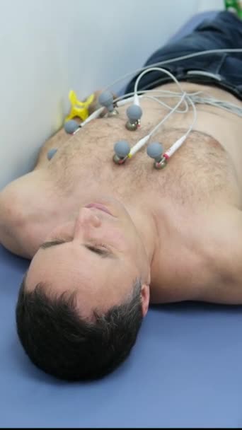 用毛茸茸的胸腔把吸盘贴在胸腔上的男人做心动图的问题不可能消失 这使得心动图进行测试的技术装置不方便 高质量的 — 图库视频影像