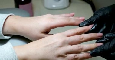 Kadın tırnak bakımı yağı, losyon, nemlendirici ya da E vitamini içeren bir serum kullanıyor. Kırılgan kuru çivi tedavisi ve güçlendirme. Ev sağlığı ve güzellik hizmetleri. Güzellik salonu manikürcüsü.