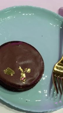 Fındıklı lezzetli karamel çikolatalı pasta ve altın çatallı yenilebilir altın kesim. Yüksek kalite 4k görüntü