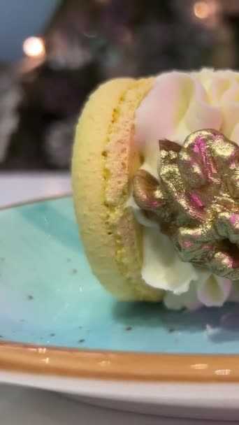 ブループレートの垂直ビデオにクルミと黄色の食用金デザートが付いているマカロン 高品質のフルHd映像 — ストック動画
