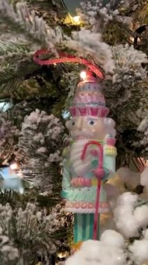 Beyaz karla kaplı Noel ağacında Noel Baba kamışlı Noel Baba heykelciği asılı. Işıklar parıldıyor. Noel, reklam metinleri için tatil yeri. Kutlama videosu. 