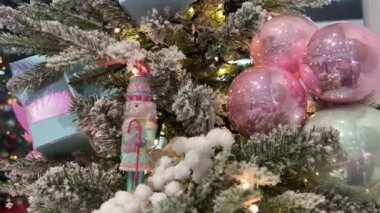 Beyaz karla kaplı Noel ağacında Noel Baba kamışlı Noel Baba heykelciği asılı. Işıklar parıldıyor. Noel, reklam metinleri için tatil yeri. Kutlama videosu. 