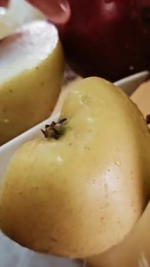 Olgun ve çıtır çıtır elma parçaları güvertede yatıyor, olgun elma parçaları tahtanın üzerinde sallanıyor soyuluyor ve olgun kırmızı elmalar dilimleniyor, lezzetli elmalar ve kabukları pişirilirken soyuluyor. Yüksek kalite