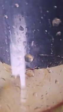 Merkezkaç sıkacağı ev yapımı havuç elma mandalina suyu. Plastik bardağı meyve suyuyla dolduruyorum. Taze sıkılmış meyve ve sebze suyu yapıyorum, yakın plan. Meyve suyu, çiğ vejetaryen yemeği.. 