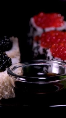 Suşi dönüşümlü olarak geliyor. Bir restoranda Japon mutfağı suşisi. Havyarlı suşi. Yüksek kalite 4K görüntü.