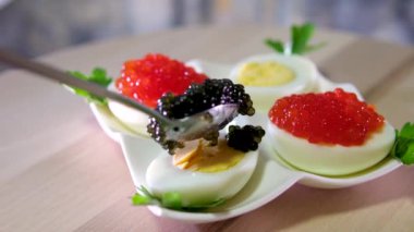 Mürekkep balığı, karides ve patates ve peynirli havyar ezmeli bıldırcın yumurtası aperatifi. Yüksek kalite