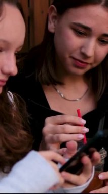 Neşeli sohbetler iki kız arkadaş bir kafede oturan genç kızlar kahve ve çay içen gülücükler atan caddelerde eğlence sohbetleri. Biraz rüzgar saçlarını geliştirir. 