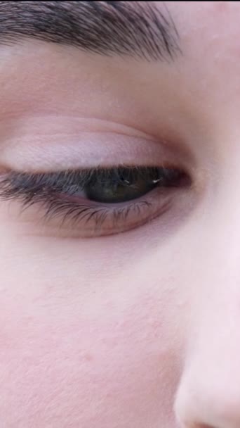 右から左の瞳孔クローズアップ女性グリーンブルーアイブローアイラッシュライトスキンアイエクササイズチェックビジョン 高品質の垂直ビデオ — ストック動画
