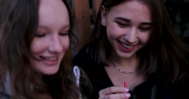 Neşeli sohbetler iki kız arkadaş bir kafede oturan genç kızlar kahve ve çay içen gülücükler atan caddelerde eğlence sohbetleri. Biraz rüzgar saçlarını geliştirir. 