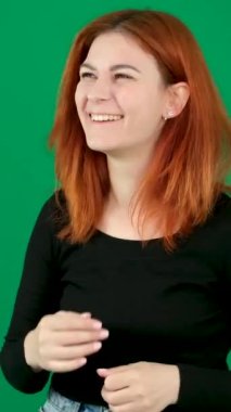 Krom anahtar stüdyo duygularında yeşil arka planda olan kızıl saçlı genç bir kadın. Kahverengi gözlü, açık tenli, Avrupalı Amerikalı. Farklı duygulara sahip genç bir kadının samimi kahkahası. 