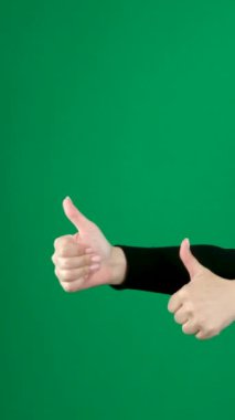 Yeşil Ekran Arkaplanına Karşı İşaret Gösteren Kadın El 'in Yakın Çekimi. Krom anahtarlı kadın başparmağını kaldırdı. Siyah kazak.