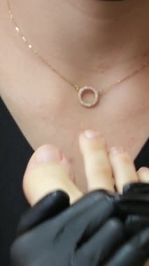 Profesyonel ayak masajı, pedikür salonunda ayak bakımı yapan siyah eldivenli kadın doktor ve maske, dairesel yoğurma hareketleriyle masaj yapıyor ayak tedavisi sorunları. pedikür salonu