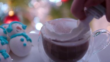 Noel ağacının yanındaki kakaolu cam bardağa krema da ekledim. Kardan adam için lezzetli yemek pişirme, yeni yıl kutlaması için. Yüksek kalite