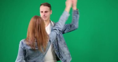 Yeşil arka planda dans eden Chromakey erkek ve kadın kot elbiseli popüler Latin Amerika dans gülümsemesinden dans ederek birlikte zaman geçiriyorlar. sağlığın korunması
