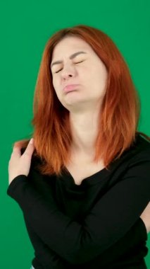 dikey video. Krom anahtarlı bir stüdyoda yeşil saçlı genç bir kadın kızıl saçlı bir kadın yumuşak bir dudak içti üzgün bir kafa eğildi melankolik, kahverengi gözlü bir Amerikalı. Kanada. 