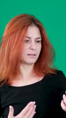 dikey video. Krom anahtar stüdyo duygularında yeşil arka planda olan kızıl saçlı genç bir kadın. Kahverengi gözlü, açık tenli, Avrupalı Amerikalı. Kanada. 