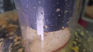 Merkezkaç sıkacağı ev yapımı havuç elma mandalina suyu. Plastik bardağı meyve suyuyla dolduruyorum. Taze sıkılmış meyve ve sebze suyu yapıyorum, yakın plan. Meyve suyu, çiğ vejetaryen yemeği.. 