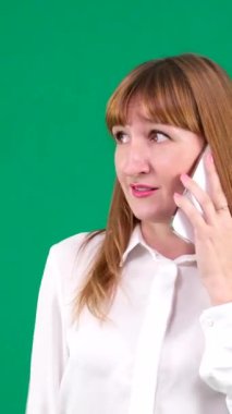 Güzel bir genç kadının portresi cep telefonu için konuşuyor. Yeşil ekran. Yüksek kaliteli konuşan telefon kadını yeşil arka plan