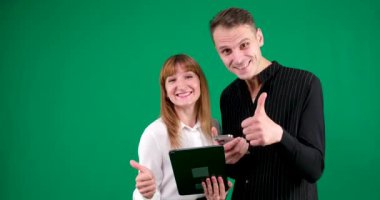 Tabletli ve telefonlu erkek ve kadın sınıf reklamcılığını gösteren şık internet indirimleri, stüdyodaki Avrupalıların yeşil arka plandaki gülümsemeleri, siyah beyaz elbise reklamları yapıyor. Yüksek kalite 