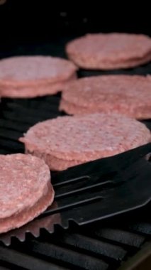 Çeşitli lezzetli yiyecekler pişiriliyor ve servis ediliyor. Lezzetli biftekli hamburgerin arka bahçesindeki barbeküye yakın plan. Yüksek kaliteli FullHD görüntüler