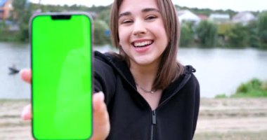Kadın eli, akıllı telefonu boş ekranla tutar ve yerine mesaj ya da bilgi içeriği koyar. Promosyon içeriğini kopyalamak için boş telefon alanı. Telefon elinde. 