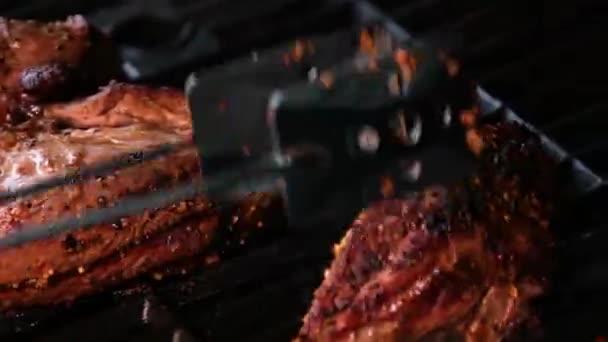 头儿用皮带把肉放在烤架上火在燃烧 热的多汁的油牛排在慢动作中烹调着 美味牛排慢动作近身 高质量的4K镜头 — 图库视频影像