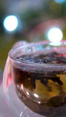 Yeşil yaz bokeh arka planında şeffaf bir fincanda kestane esmer çay. Kestane yapraklarından elde edilen ilaç tentürü. Enfüzyon içeceği. Yüksek kaliteli FullHD görüntüler