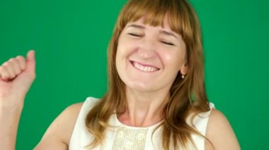 Çekici bir kadın dans eden kamera, flört, kadınlık. Krom anahtar bir stüdyoda yeşil arka planda genç bir kadın. Açık tenli, Avrupalı bir Amerikalı. Kanada