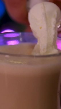 Koyu köpüklü sıcak sütlü sütlü sütlü sıcak çikolatayı cam bardakta karıştırmak. Yüksek kaliteli görüntüler