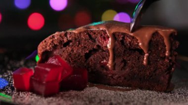 Bir kaşıkla kesilmiş lezzetli bir çikolatalı kek vişneli reçelli Brownie çikolatalı ve pudra şekerli kırmızı paletli lezzetli bir tatlı akşam yemeği. Yüksek kalite