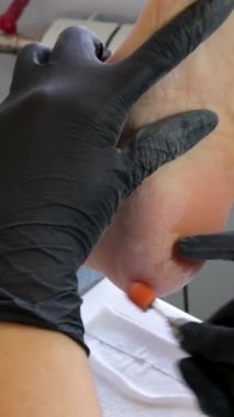 Genç bir kadın güzellik salonundaki kesiciyle pedikür yaptırıyor. Yüksek kalite 4k görüntü