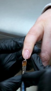 Manikür salonundaki kadının, metal tırnak törpüsüyle güzellik uzmanı tarafından manikür yapıldığı yakın çekim. Spa merkezinde manikür yaptıran bir kadın. Güzellik uzmanı lüks salondaki bir müşteriye çivi çakıyor. Yüksek kalite