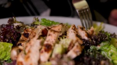 Brokoliden nazikçe brokoli ve pencerenin yanındaki tavuklu salata tabağından çatal topla. Sebzeli ve beyaz tabakta etli besleyici bir yemek. Dengeli diyet. Yüksek kalite 