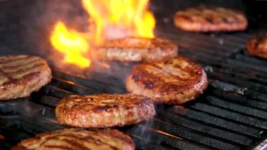 Pirzolalar ızgarada kızartılmış tavuk sosu ve ızgarada kaburga ve açık hava bifteği. Yakın çekim ızgara barbekü biftek bifteği. Alevler yavaşça yükseliyor 