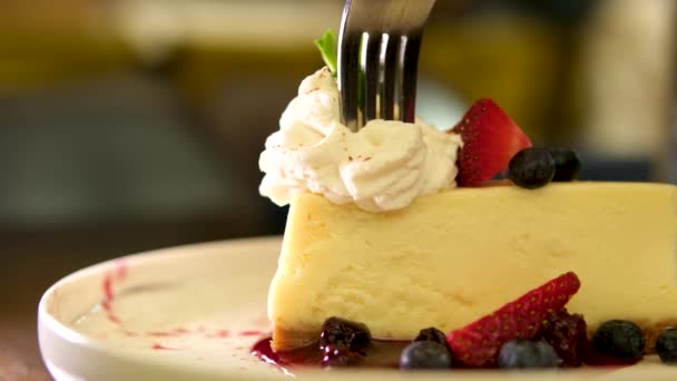 草莓芝士蛋糕放在薄薄的木制桌子地基上的盘子里 高质量的4K镜头 — 图库视频影像