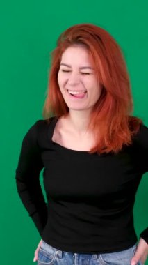 dikey video. Krom anahtar stüdyo duygularında yeşil arka planda olan kızıl saçlı genç bir kadın. Kahverengi gözlü, açık tenli, Avrupalı Amerikalı. Kanada. 