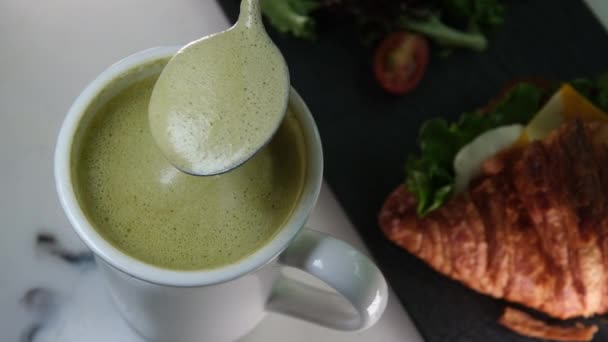 侍者在桌上放上热茶和绿色泡沫 代替卡布奇诺 减少咖啡因的摄入 代之以更健康的玛瑙茶 日本大麻茶素食消费 高质量的 — 图库视频影像
