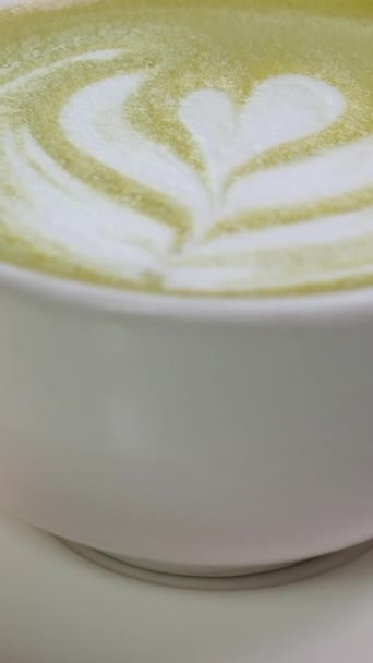 侍者把热马茶配上绿色泡沫 代替卡布奇诺的垂直视频来减少咖啡因的摄入 代之以更健康的男子茶 素食主义者对日本大麻茶的消费 — 图库视频影像