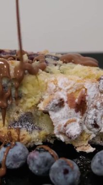 Yaban mersinli turtanın üzerine çikolata serpiştirin. Erimiş siyah çikolatayı, Gugelhupf olarak da bilinen mermer halka kekin üzerine dökün. Yüksek kalite 4k görüntü