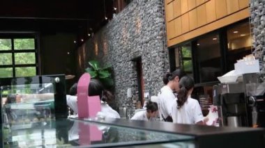 La Foret kafe lokantası tatlıları ve kekler bir sürü kruvasan, önlüklü beyaz tişörtlü Asyalı satıcıların taze pişmiş lezzetli yiyecekleri paketliyor. Vancouver Kanada MÖ 01.02.2024.
