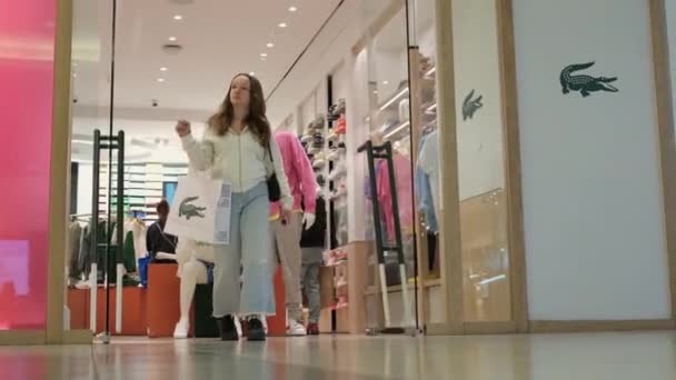 Compras Tienda Lacoste Una Chica Sale Con Una Bolsa Papel — Vídeos de Stock