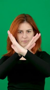 Close-up female portrait young caucasian woman showing prohibition sign crossing arms making refusal gesture negative shaking head dissatisfied serious girl says no refuses demonstrates stop gesture.