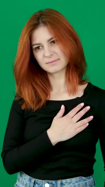 緑色の背景にある女性は 彼女の心と約束に手を置くために頭を噛みます 敬意を持って 緑色の染色体の背景に敬意を表するあなたの心のシンボルに手を置きます 高品質で — ストック動画