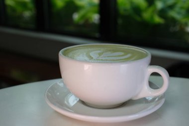 Yarın akşam bir restoranda servis edilecek sütlü yeşil çay eşliğinde beyaz bir fincanda eşleşen içecekler. diyet. Yüksek kalite 