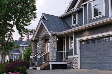 Özel yapım, yerleşim yerlerinde üç katlı garaj kapısı olan lüks bir ev inşa etti. Vancouver Surrey Kanada 'nın banliyöleri. Yüksek kalite 